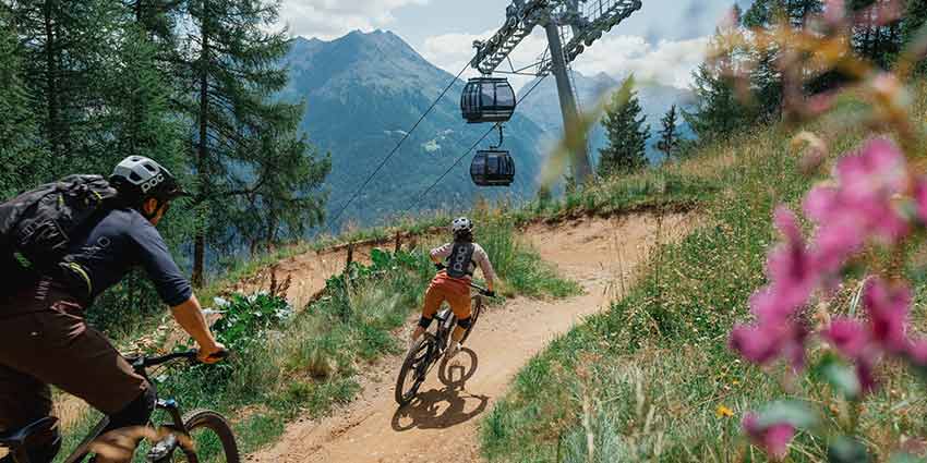 Sommer Bikestrecke für Downhill mit Gondelbahn und Bergwelt im Hintergrund