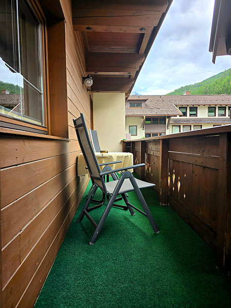 Aussicht auf die Bergewelt von Sölden vom Balkon mit einfachen Stühlen und einem Tisch